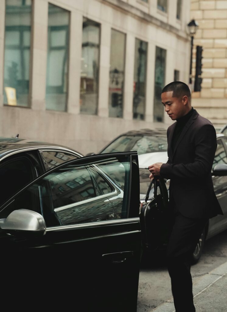 Chauffeur in a suit opening a car door